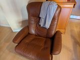 un fauteuil en cuir marron recouvert d'une couverture bleue
