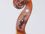 a close up of the back of a violin with a fiddle in the foreground