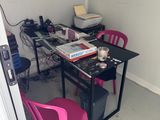 une chaise rose placée devant un bureau sur lequel se trouve un ordinateur