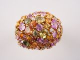 une image représentant une bague ornée de pierres multicolores sur un fond blanc