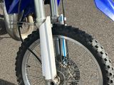 a blue dirt bike parked in a parking lot
