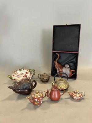 une boîte contenant des théières et d'autres objets, posée sur une table