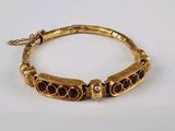 une photo d'un bracelet en or orné de grenats et de perles