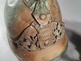 a bronze helmet with a coat of arms and shield on it