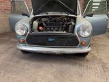 a small car with the hood open and the engine in the trunk