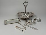 a silver plate with spoons, spoons, and other items on it