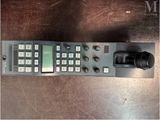 a close up of a remote control on a wooden table