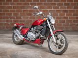 a red motorcycle parked in front of a brick wall