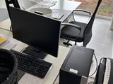 a desk with a computer, keyboard, mouse, and other items on it
