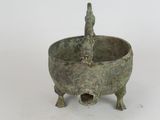 a small bronze bowl with a bird on it