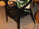 a black table with a black chair and a black table with a green cushion