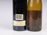 two bottles of wine sitting next to each other on a white surface