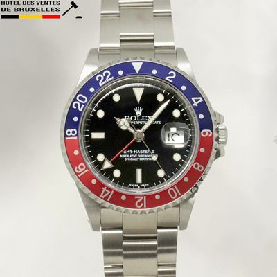 a rolex watch with a red, blue and red bezel
