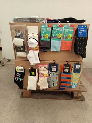 several pairs of socks are stacked on a pallet in front of a wall