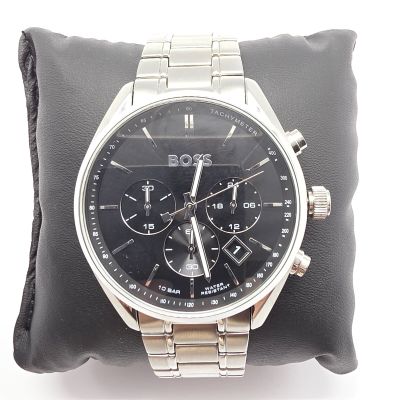 la montre est posée sur un coussin, sur une surface blanche