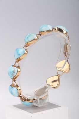 bracelet turquoise et or exposé sur un socle blanc