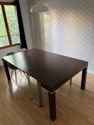 une table et des chaises en bois dans une pièce avec du papier peint