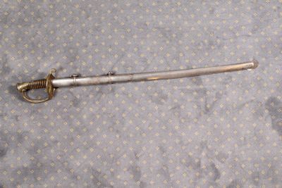 une petite épée posée sur un lit