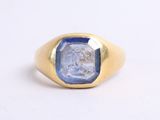 a close up of a gold ring with a blue stone in the center