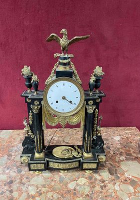 a black and gold clock on a marble table