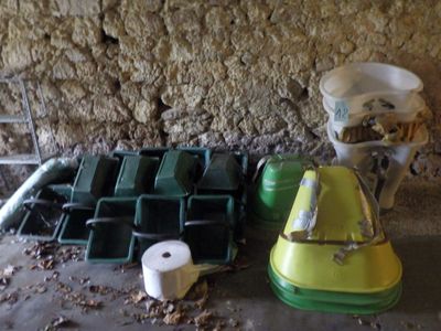 des toilettes, un seau et un seau d'eau posé par terre