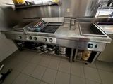 a kitchen with a stove, sink, and pots and pans