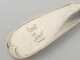 a silver spoon with a silver handle on a table
