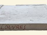 cement block with a red inscription on it that says louve