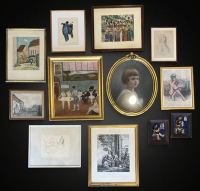 many framed pictures on the wall of this room