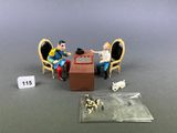 two figurines of people sitting at a table playing chess