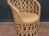 une chaise en osier sur laquelle est posé un coussin jaune