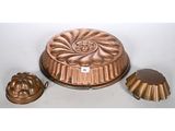 an image of a cake pan and two molds sitting on a table