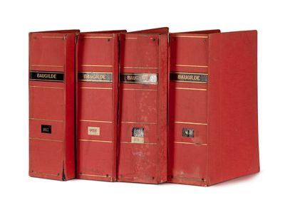 trois livres rouges sont empilés sur une surface blanche