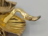 a gold statue of a bird with a leaf on it ' s head