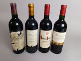 quatre bouteilles de vin sont alignées sur une table