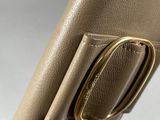 the back of a brown purse with a gold ring on it