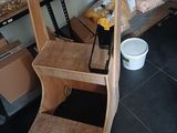 a wooden shelf with shelves and a bucket of food on it