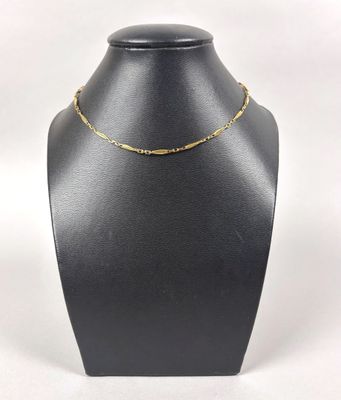 a black mannequin with a gold chain on it