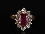 une bague en or sertie d'un rubis entouré de diamants blancs