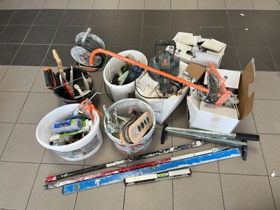 un tas d'outils par terre, à côté des toilettes