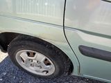 a small green van parked on the side of the road