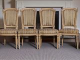 plusieurs chaises et une table dans une pièce avec une cheminée en arrière-plan