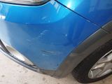 a close up of a blue car with a denting on it
