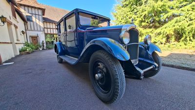 an old blue truck parked in front of a house