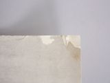 someone is holding a piece of paper with a brown stain on it