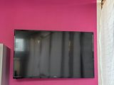 une télévision à écran plat accrochée à un mur rose dans une pièce