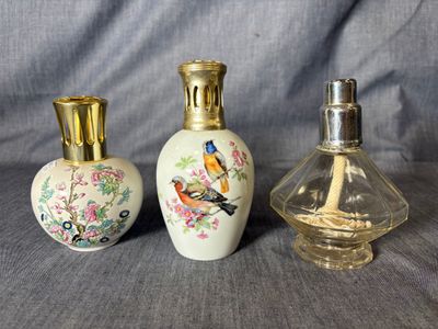 trois petites bouteilles en verre ornées d'oiseaux, posées les unes à côté des autres