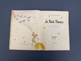 un livre ouvert avec l'image d'une petite fille tenant un ballon