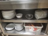 many plates and bowls on the shelf in the kitchen