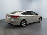 the back end of a silver car in a room with a white wall